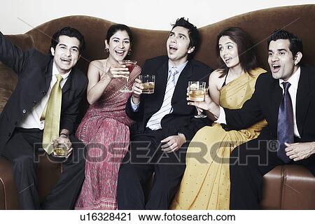 Three young men and two young women holding glasses View Large Photo Image Stock Image - Three young men and two young women holding glasses. Fotosearch