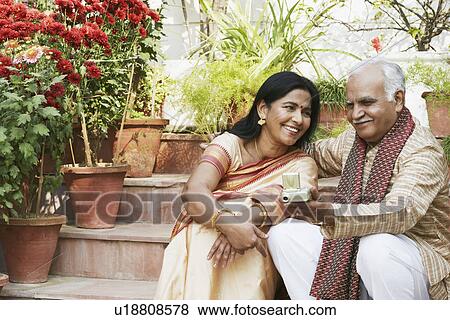 Stock Photo - Close-up of a mature couple sitting on steps. Fotosearch