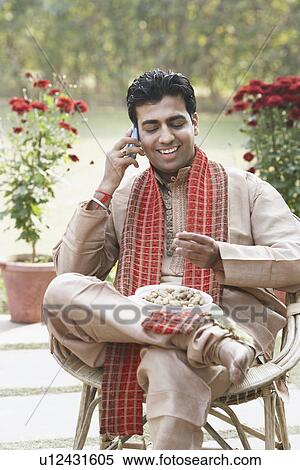 Stock Photography - Close-up of a young man talking on a mobile phone. Fotosearch