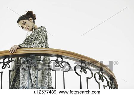 Low angle view of a young woman standing in the balcony View Large Photo Image Stock Photo - Low angle view of a young woman standing in the balcony. Fotosearch