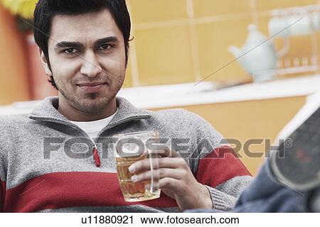 Stock Image - Portrait of a young man holding a beer stein. Fotosearch