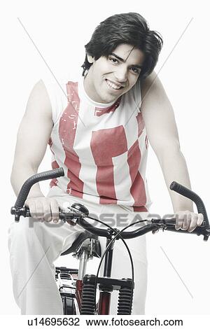 Portrait of a young man sitting on a bicycle View Large Photo Image Stock Image - Portrait of a young man sitting on a bicycle. Fotosearch