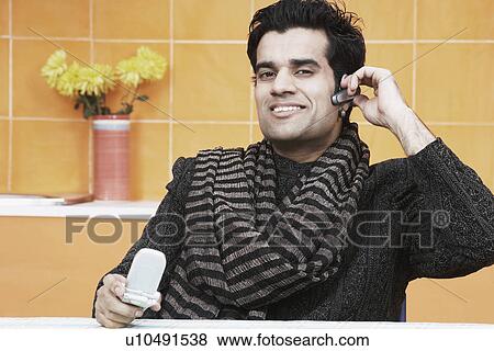Stock Photo - Portrait of a young man wearing a hands free device. Fotosearch