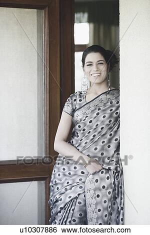 Stock Photograph - Portrait of a young woman leaning against a wall. Fotosearch