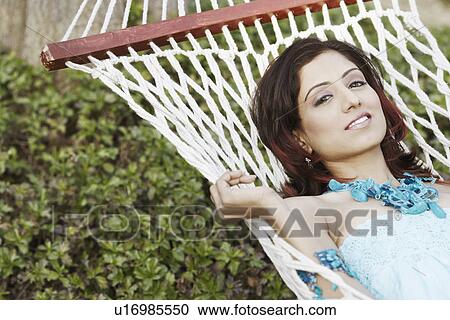 Stock Image - Portrait of a young woman lying in a hammock. Fotosearch