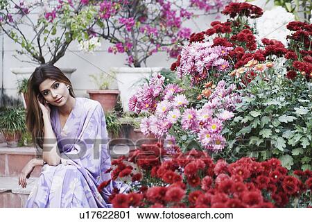 Stock Image - Portrait of a young woman sitting on steps. Fotosearch