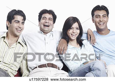 Stock Photo - Portrait of four friends sitting together on a couch. Fotosearch