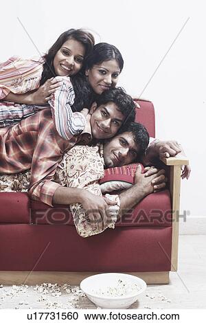 Portrait of two young men and two young women lying on top of each other smiling View Large Photo Image Stock Image - Portrait of two young men and two young women lying on top of each other smiling. Fotosearch