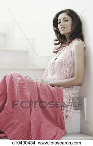 Side profile of a young woman sitting on a staircase View Large Photo Image Picture - Side profile of a young woman sitting on a staircase. Fotosearch