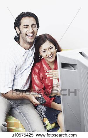 Stock Photography - Young couple watching television. Fotosearch