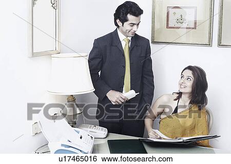 Stock Photograph - Businessman and a businesswoman in an office. Fotosearch