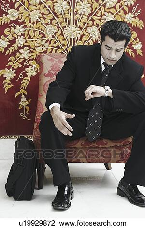 Businessman looking at his wristwatch View Large Photo Image Stock Image - Businessman looking at his wristwatch. Fotosearch