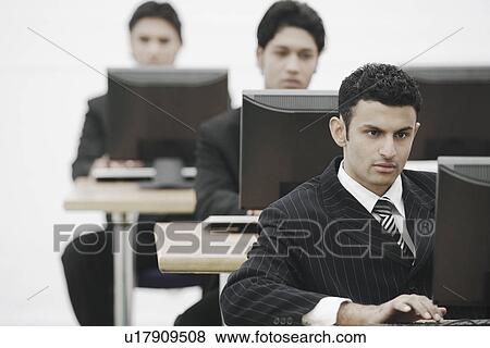 Businessman working on a computer View Large Photo Image Stock Photo - Businessman working on a computer. Fotosearch