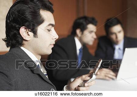 Stock Photograph - Close-up of a businessman using a mobile phone. Fotosearch