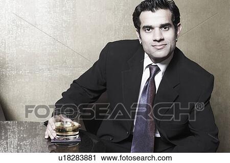 Portrait of a businessman holding a glass of whiskey View Large Photo Image Stock Image - Portrait of a businessman holding a glass of whiskey. Fotosearch