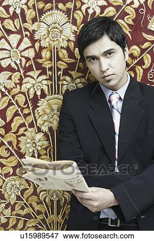 Stock Photo - Portrait of a businessman holding a newspaper. Fotosearch