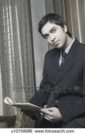 Portrait of a businessman holding a newspaper View Large Photo Image Stock Photograph - Portrait of a businessman holding a newspaper. Fotosearch