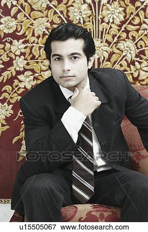 Portrait of a businessman sitting on a chair View Large Photo Image Stock Photo - Portrait of a businessman sitting on a chair. Fotosearch