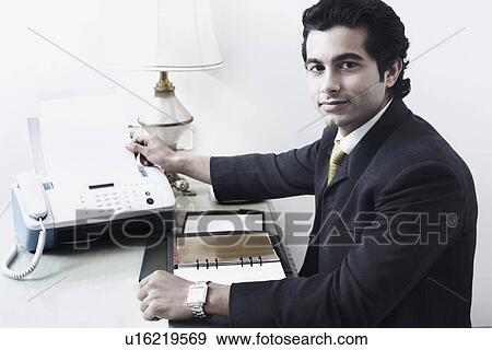 Portrait of a businessman using a fax machine View Large Photo Image Stock Photo - Portrait of a businessman using a fax machine. Fotosearch
