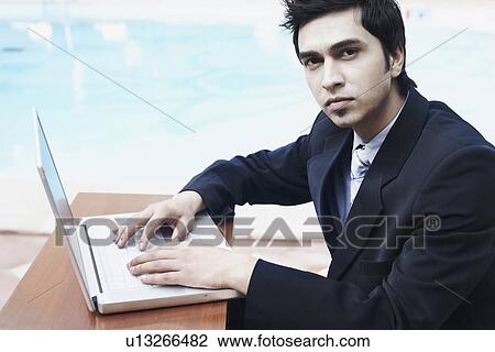 Stock Image - Portrait of a businessman using a laptop. Fotosearch