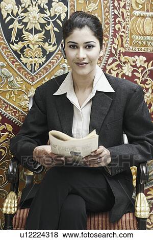 Portrait of a businesswoman holding a newspaper View Large Photo Image Stock Photo - Portrait of a businesswoman holding a newspaper. Fotosearch