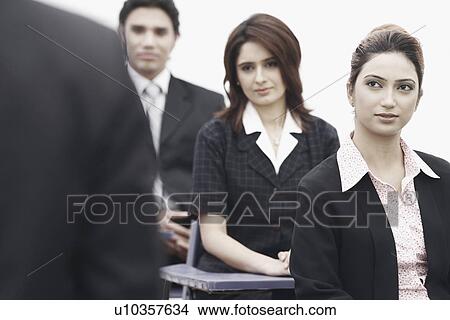 Portrait of two businesswomen sitting with a businessman View Large Photo Image Picture - Portrait of two businesswomen sitting with a businessman. Fotosearch