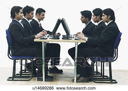 Side profile of a group of businessmen working on computers in an office View Large Photo Image Stock Photograph - Side profile of a group of businessmen working on computers in an office. Fotosearch