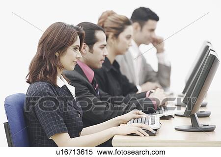 Two businessmen and two businesswomen sitting in front of computers View Large Photo Image Stock Photography - Two businessmen and two businesswomen sitting in front of computers. Fotosearch