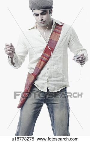 Stock Photography - Close-up of a young man listening to an MP3 player. Fotosearch