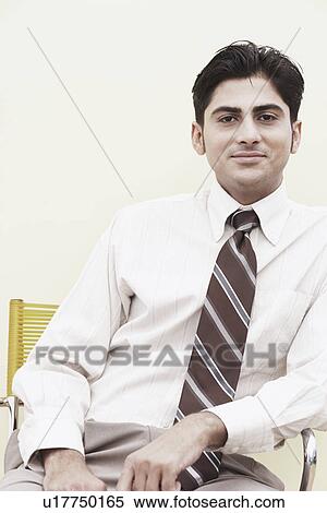 Portrait of a businessman sitting on a chair View Large Photo Image Stock Photography - Portrait of a businessman sitting on a chair. Fotosearch