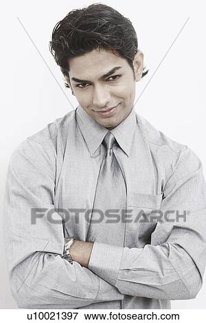 Stock Photo - Portrait of a businessman standing with his arms crossed. Fotosearch