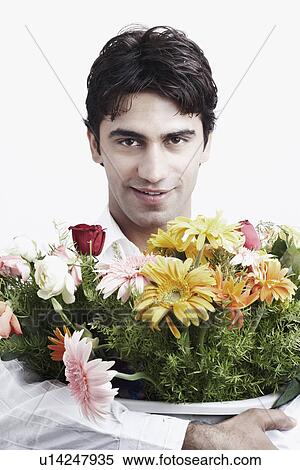 Stock Photography - Portrait of a young man holding a bouquet of flowers. Fotosearch