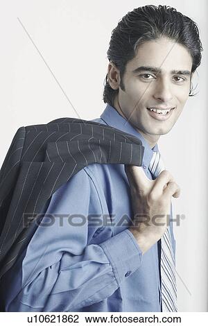Portrait of a young man holding his coat over his shoulder View Large Photo Image Stock Image - Portrait of a young man holding his coat over his shoulder. Fotosearch