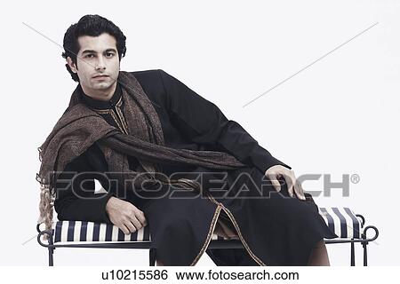 Stock Photograph - Portrait of a young man leaning on a bench. Fotosearch