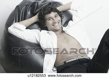 Portrait of a young man sitting on a bean bag View Large Photo Image Stock Image - Portrait of a young man sitting on a bean bag. Fotosearch