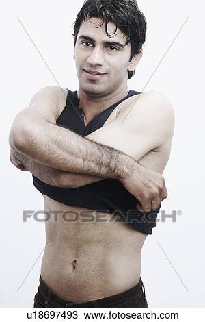 Stock Image - Portrait of a young man undressing. Fotosearch