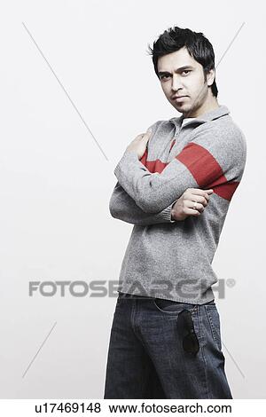 Stock Photo - Portrait of a young man with his arms crossed. Fotosearch