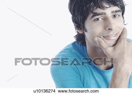 Portrait of a young man with his hand on his chin View Large Photo Image Picture - Portrait of a young man with his hand on his chin. Fotosearch