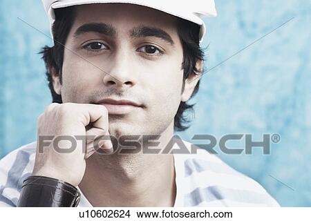 Picture - Portrait of a young man with his hand on his chin. Fotosearch