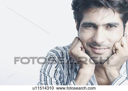 Portrait of a young man with his hands on his chin View Large Photo Image Stock Image - Portrait of a young man with his hands on his chin. Fotosearch