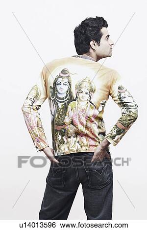 Rear view of a young man standing with his hands in his pockets View Large Photo Image Stock Photograph - Rear view of a young man standing with his hands in his pockets. Fotosearch