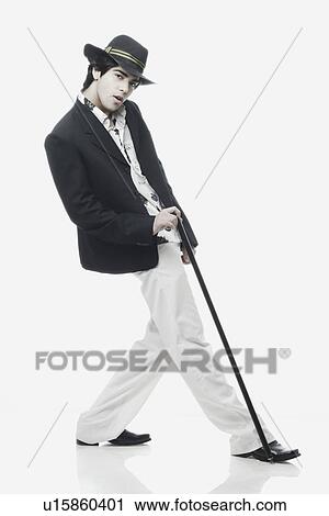 Side profile of a young man posing with a cane View Large Photo Image Stock Image - Side profile of a young man posing with a cane. Fotosearch