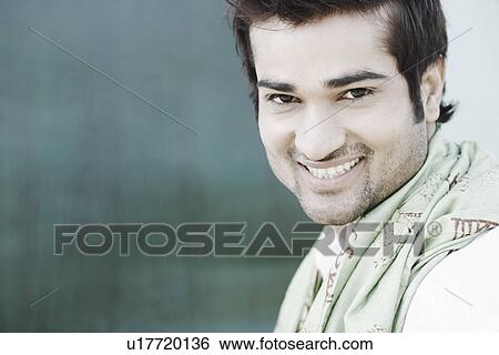 Stock Photograph - Side profile of a young man smiling. Fotosearch