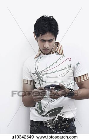 Young man holding a CD and listening to music View Large Photo Image Stock Photo - Young man holding a CD and listening to music. Fotosearch