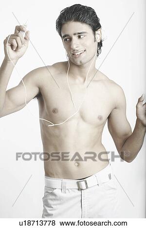 Young man listening to music wearing headphones View Large Photo Image Stock Photo - Young man listening to music wearing headphones. Fotosearch