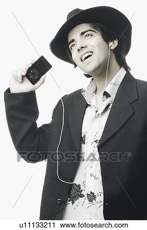Stock Image - Close-up of a young man listening to an MP3 player. Fotosearch