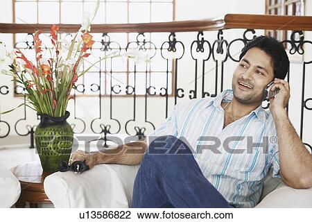 Close-up of a young man talking on a mobile phone View Large Photo Image Stock Image - Close-up of a young man talking on a mobile phone. Fotosearch