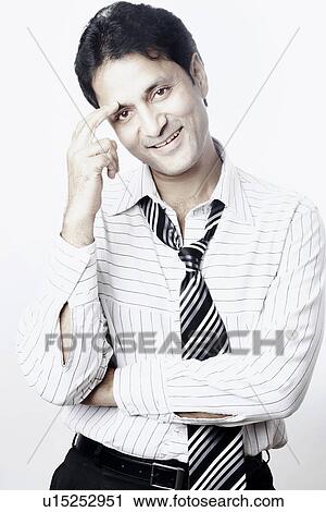 Stock Image - Portrait of a businessman with his finger on his forehead. Fotosearch