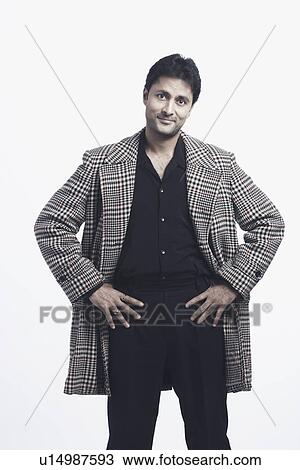 Stock Image - Portrait of a mid adult man standing with arms akimbo. Fotosearch