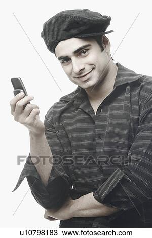 Stock Image - Portrait of a young man holding a mobile phone. Fotosearch